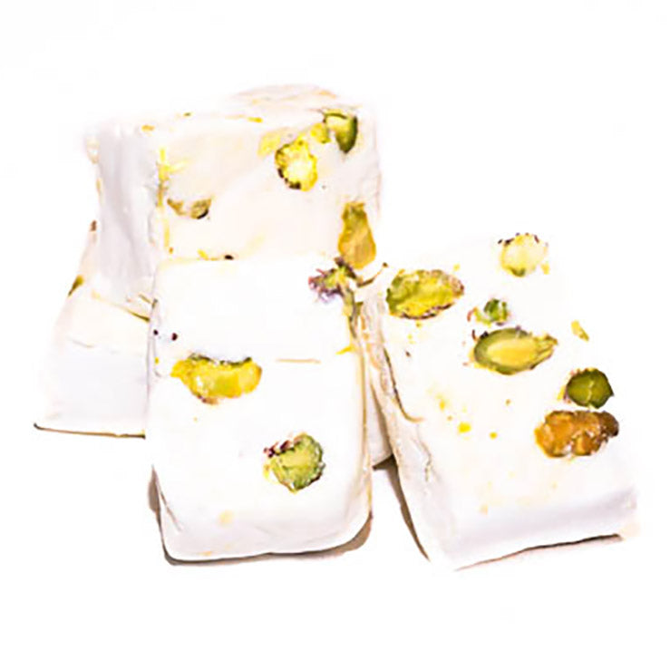 Piece of Master Delight pistachio nougat with visible pistachio nuts on a white background.