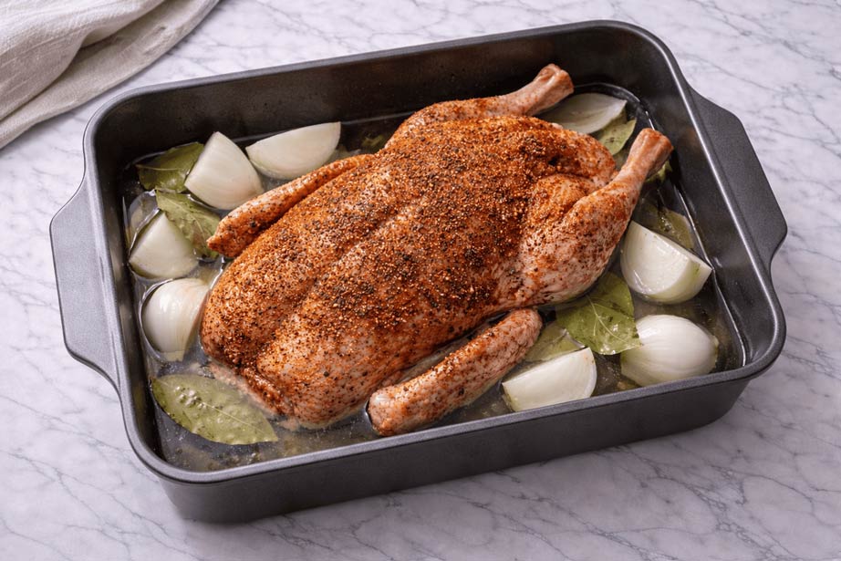Golden crispy roasted duck in baking tray with butter for Ramadan 2026