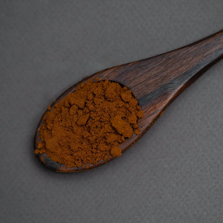 Wooden spoon filled with light roast coffee powder closeup Elsouk