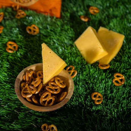 Scattered cheese pretzels with cheese chunks on grass from Elsouk