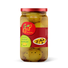 Jar of Elsouk Lemon Pickled ليمون معصفر with bright yellow pickled lemons in brine, ready for culinary use.