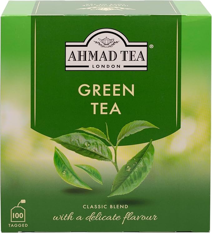Box of Ahmad Tea Green Tea with green tea leaves and packaging, showcasing the brand and fresh tea product.
