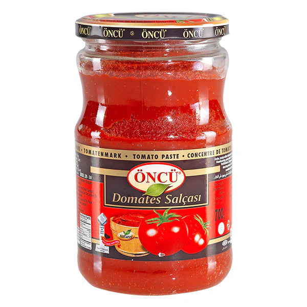 Oncu tomato paste in a 700g jar, showing a close-up of the rich, thick red tomato paste with a spoon ready for cooking.